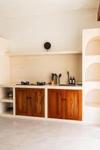 a kitchen with wooden cabinets and a sink at Villa Papì Uluwatu 1 in Bingin Beach