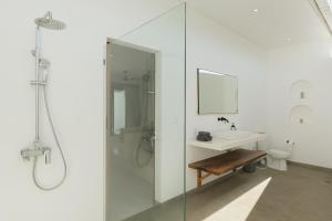 a white bathroom with a sink and a shower at Villa Papì Uluwatu 1 in Bingin Beach +7 photos