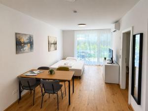 a bedroom with a bed and a table and chairs at Am See 18 in Podersdorf am See