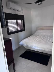 a small bedroom with a bed and a window at Quiet spot in Qiryat Ata +2 photos