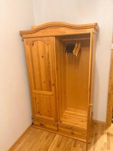 a wooden cabinet in the corner of a room at Pine Apartment, Riga in Riga +1 photo