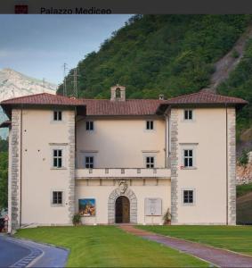 a large white building with a mountain in the background at LA CASETTA di AURORA in Riomagno