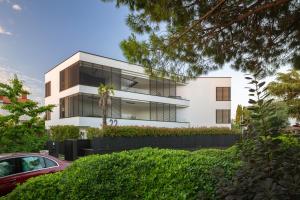 a white building with a palm tree in front of it at Residence Maru' in Rovinj