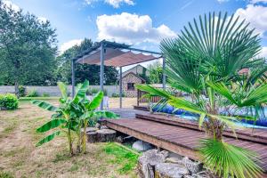 a wooden boardwalk in a garden with a pavilion at Bluedothotels location France in Magnac-Laval