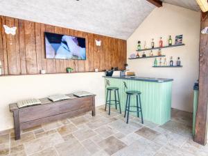 a bar with a bench and stools in a room at Bluedothotels location France in Magnac-Laval