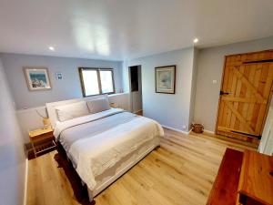 a bedroom with a large bed and a wooden door at Bluedothotels location France in Magnac-Laval +34 photos