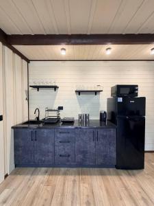 a large kitchen with a black refrigerator in a room at Подих Свободи in Sloboda +16 photos