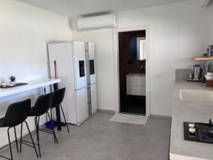 a kitchen with a refrigerator and a counter with stools at Quiet spot in Qiryat Ata