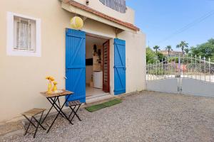 a house with blue doors and a table in front of it at O Sole Mio Zen Haven in Valras-Plage