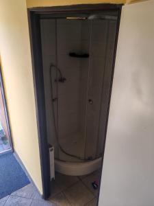 a glass shower in a bathroom with a toilet at Penzion Nord in Hora Svatého Šebestiána