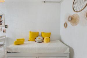 a room with a bed with yellow pillows at O Sole Mio Zen Haven in Valras-Plage