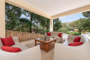 an outdoor patio with white chairs and a table at Casa Gotmar 132 in El Port