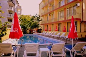 a pool with chairs and umbrellas next to a building at Ryor Hotel - Restaurant & Free Parking in Sunny Beach