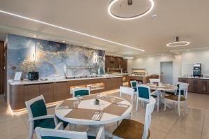 a restaurant with tables and chairs and a kitchen at Solimar Topaz - Adults Only in Tavronitis +16 photos