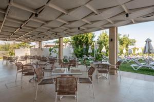 a restaurant with tables and chairs and a patio at Solimar Topaz - Adults Only in Tavronitis
