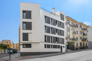 a white building with black windows on a street at MÁ HOMES Postigos in Málaga