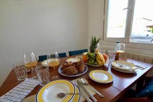 a wooden table with plates of food and glasses of wine at Casa Morera by Rental Olé in Torre-Pacheco