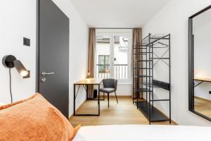 a bedroom with a desk and a ladder to a room at Global Living Passau Ludwigplatz in Passau