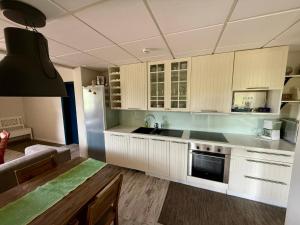 a kitchen with white cabinets and a stove top oven at Gålåseter Jotunheimen 5 in Gålå