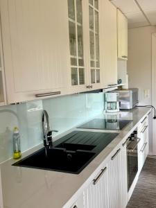 a kitchen with white cabinets and a sink at Gålåseter Jotunheimen 5 in Gålå