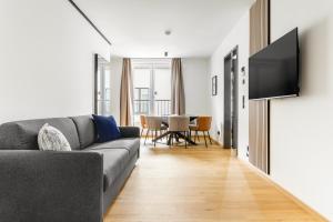 a living room with a couch and a table at Global Living Passau Ludwigplatz in Passau