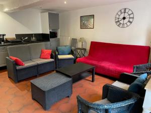 a living room with a red couch and chairs at Les Logis de la Vaucouleurs in Rosay