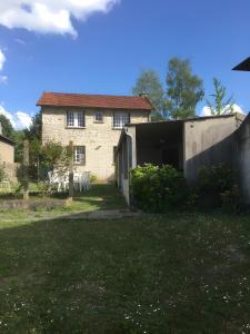 a large stone house with a yard in front of it at Les Logis de la Vaucouleurs in Rosay