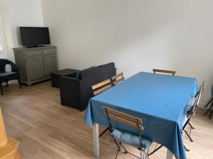 a blue table and chairs in a room with a tv at Les Logis de la Vaucouleurs in Rosay