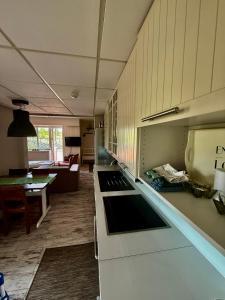 a kitchen with white cabinets and a living room at Gålåseter Jotunheimen 5 in Gålå +2 photos