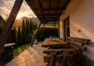 a wooden table and bench on a patio with a view at UMANI Retreat in Buşteni