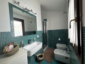 a bathroom with a sink and a toilet and a mirror at Casa Giulia in Palau