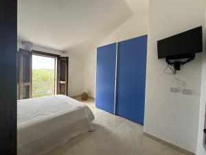a bedroom with a bed and a blue cabinet at Casa Giulia in Palau