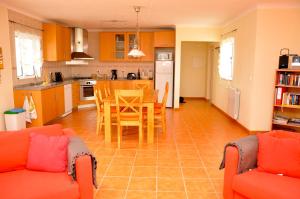 a kitchen with orange furniture and a table and chairs at Casa Sol in Aljezur