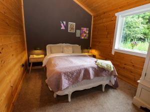 a bedroom with a bed in a room with a window at Bulrush Cabin in Carlisle