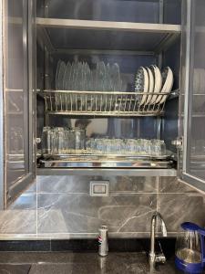 an open refrigerator with plates and dishes on a shelf at New Alamen Towers in El Alamein