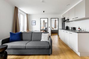a living room with a couch and a kitchen at Global Living Passau Ludwigplatz in Passau