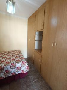 a bedroom with a bed and wooden cabinets at Phezulu Air B & B in Richards Bay