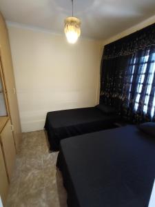 a small room with two beds and a window at Phezulu Air B & B in Richards Bay