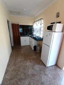 a kitchen with a white refrigerator and a counter at Phezulu Air B & B in Richards Bay
