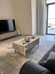 a living room with a coffee table in front of a tv at New Alamen Towers in El Alamein