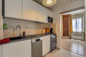 a kitchen with a sink and a washing machine at Jacuzzi de charme pour 2 in Nîmes +11 photos