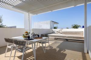 a white table and chairs under a white umbrella at Villa Argentea in Ragusa
