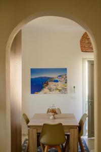 a dining room table with chairs and a painting on the wall at Santana Apartments in Perivolos