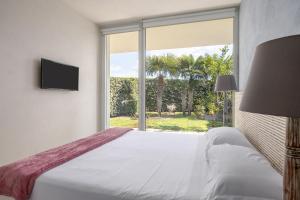 a bedroom with a bed and a large window at Villa Argentea in Ragusa