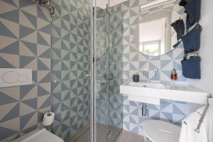a bathroom with blue and white tiled walls and a shower at Villa Argentea in Ragusa +19 photos