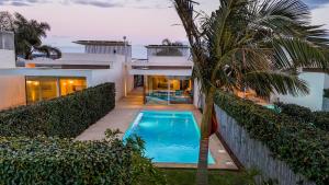 a house with a swimming pool and a palm tree at Villa Argentea in Ragusa