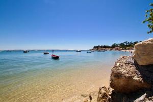 a group of boats in the water on a beach at LA VILLA DU CAP in Cap-Ferret