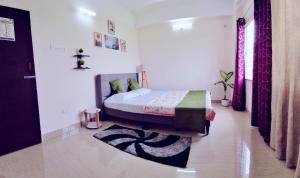 ein Schlafzimmer mit einem Bett und einem Teppich in der Unterkunft Transit Nest 1BHK in Guwahati