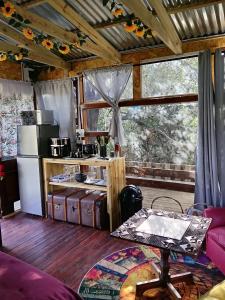 a kitchen with a counter with a refrigerator and a table at 11 Mountain Stream Hot Tub Self Catering in Gordonʼs Bay