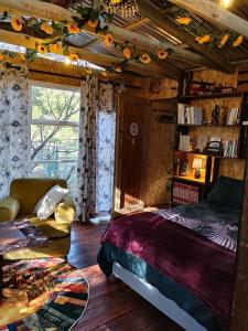 a bedroom with a bed and a couch and a window at 11 Mountain Stream Hot Tub Self Catering in Gordonʼs Bay